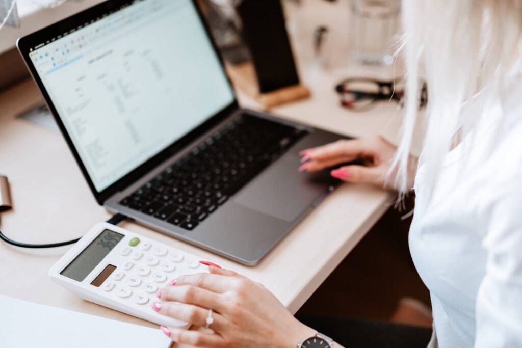 Woman Working with Laptop and Calculator Free Photo