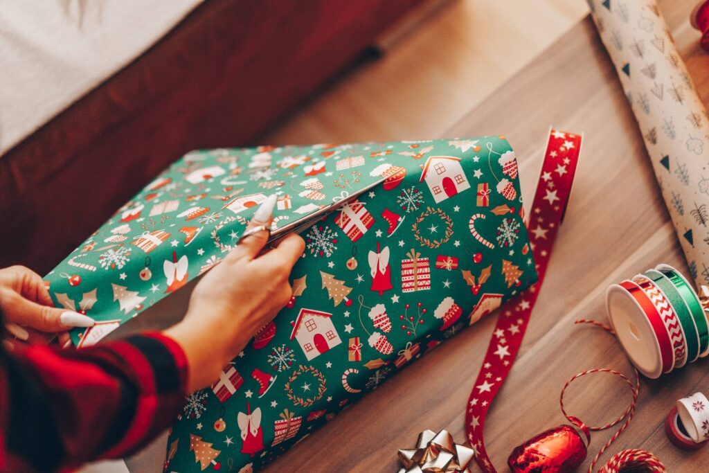 Woman Wrapping a Gift in Christmas Paper Free Photo