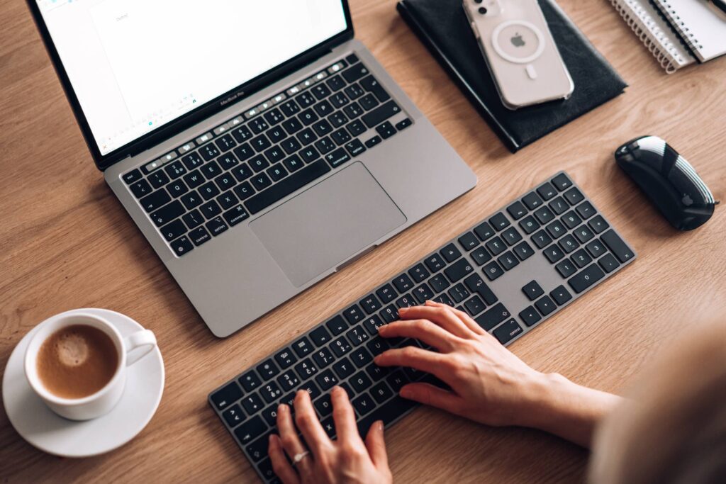 Woman Writing Documents on Laptop with Full Size Keyboard Free Photo