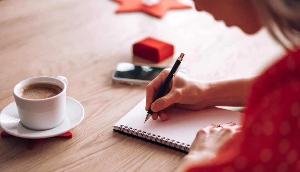 Woman Writing Her Thoughts and Ideas in a Diary Free Photo