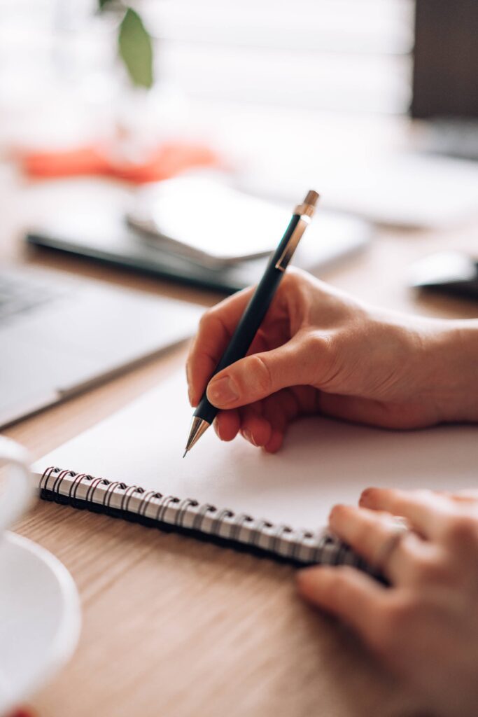 Woman Writing in a Diary with a Pen Free Photo