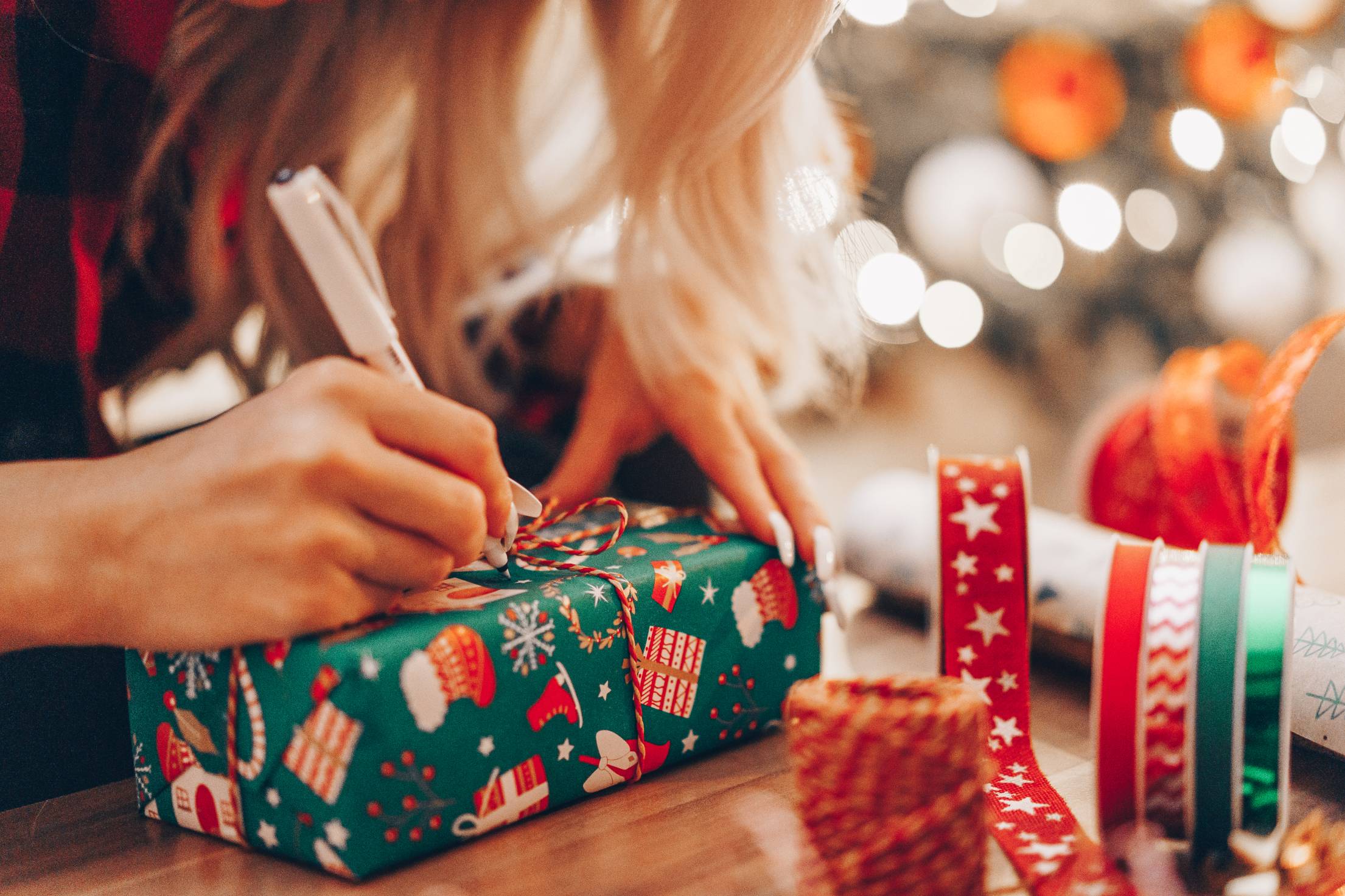 Woman Writing Name on Christmas Present Free Photo