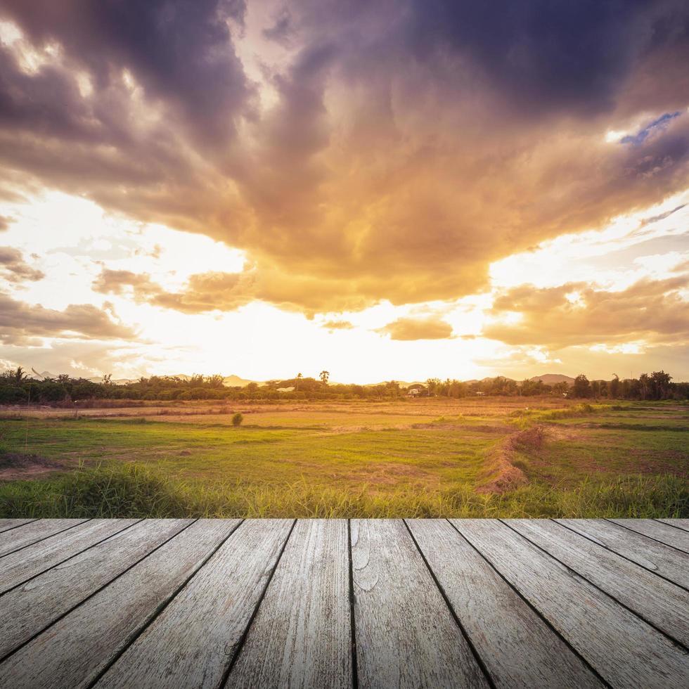 wood floor and field meadow with beautiful sunset Stock Free