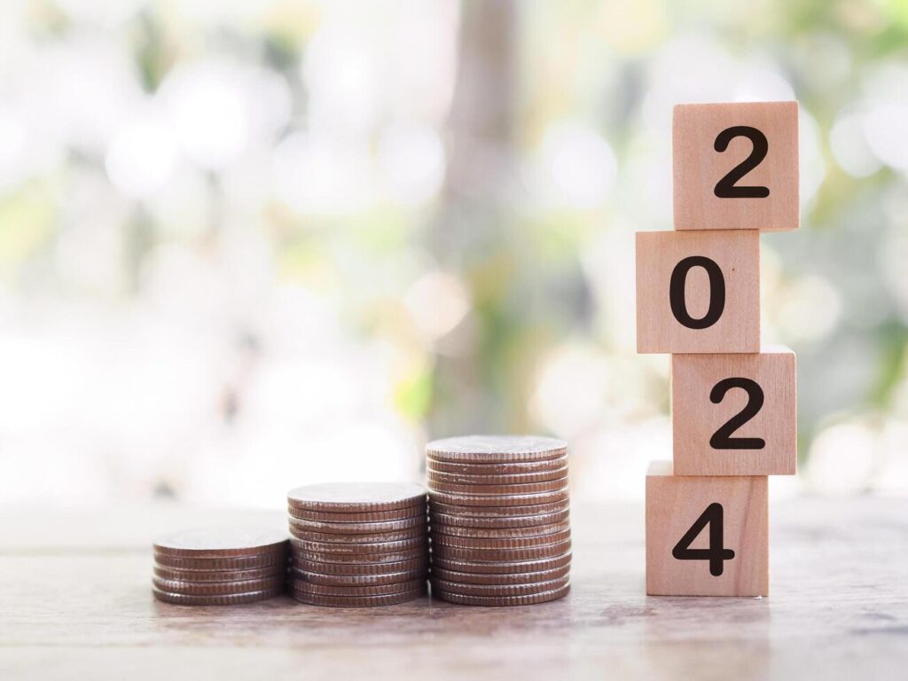 Wooden blocks with the number 2024 and stack of coins. The concept of saving money, Financial, Investment and Business growing in year 2024. Stock Free