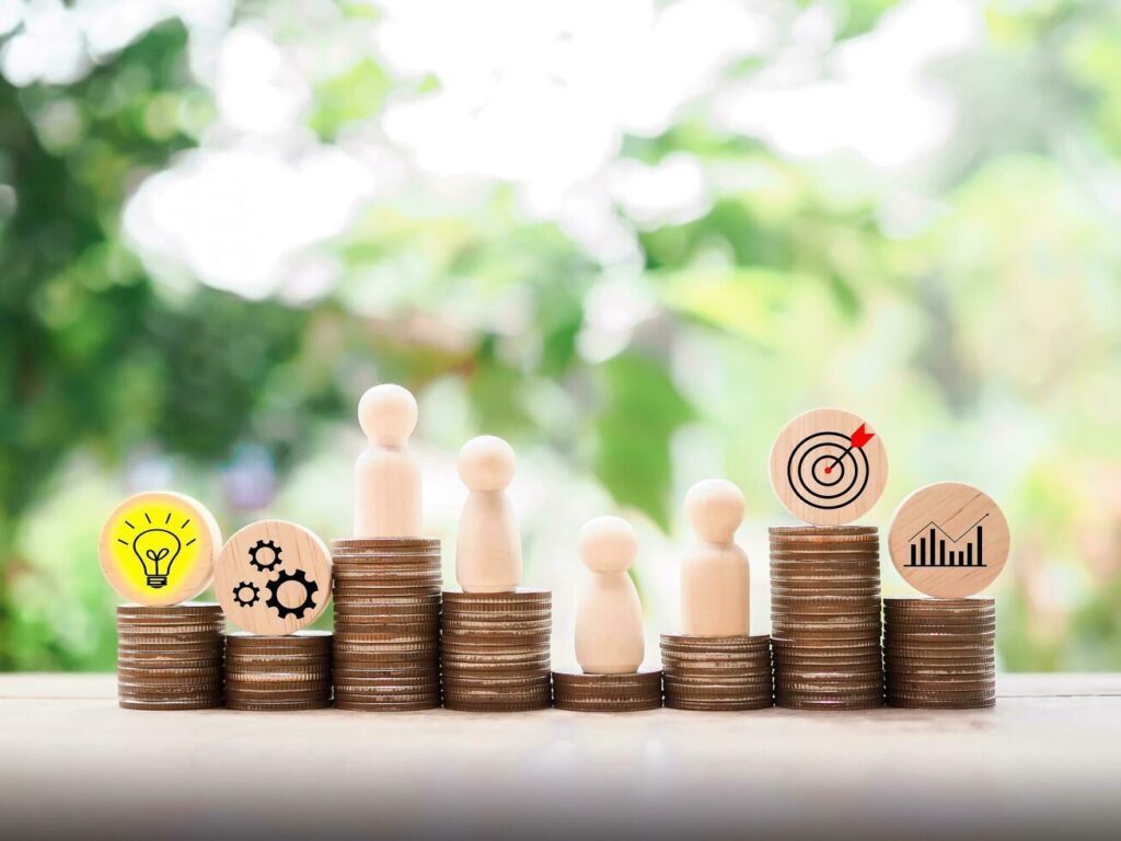 Wooden human figure standing on stack of coins with business strategy icons, Action plan and business process management concept. Stock Free