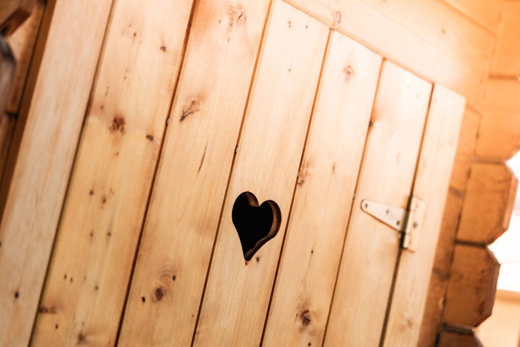 Wooden Outdoor Toilet with a Carved Heart in The Door Free Photo