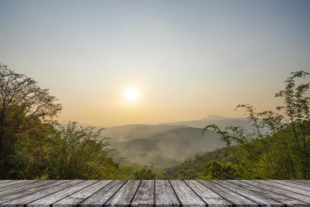 Wooden table and blur of beauty, sunset sky, and mountains as background. Free Photo