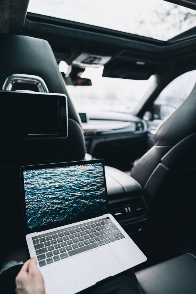 Working on a MacBook on Rear Seats in a Car Free Photo