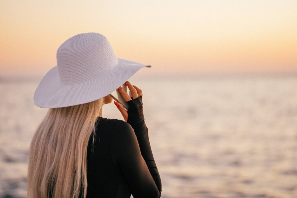 Young Blonde Woman Calling During Sunset by the Sea Free Photo