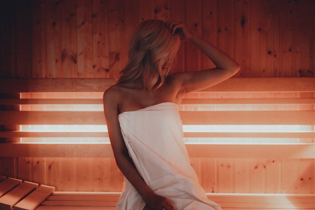 Young Blonde Woman Sitting in Finnish Sauna Free Photo