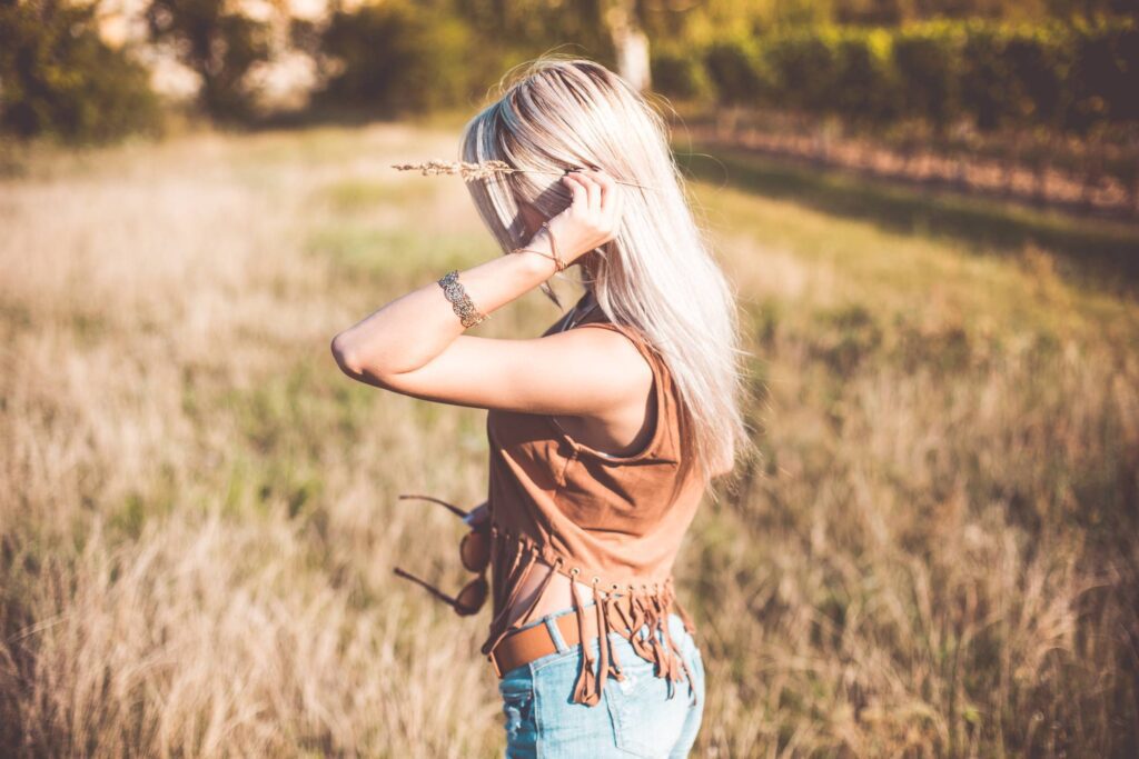 Young Boho Woman Enjoying Sun and Holding Flower Stem Free Photo