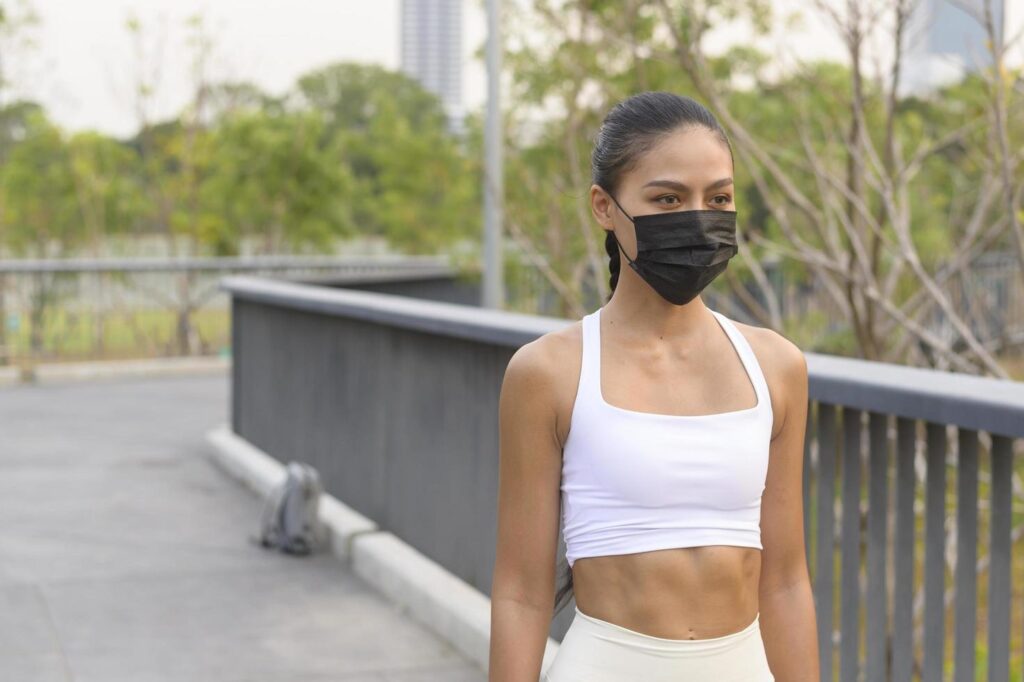 Young fitness woman in sportswear taking face mask in while exercise in city park, Health and Lifestyles. Stock Free