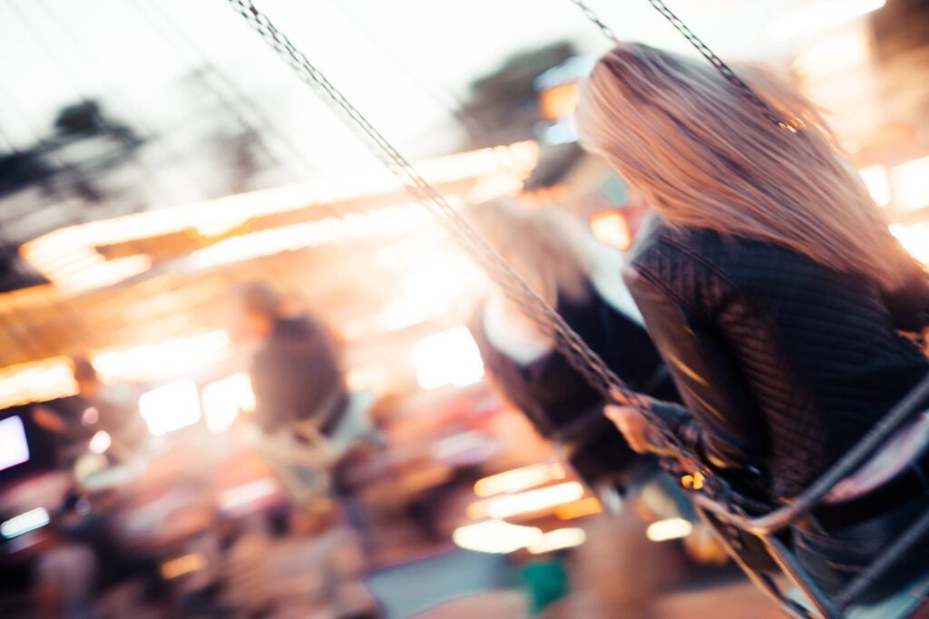 Young Girl Enjoying Crazy Ride on Swing Carousel Free Photo