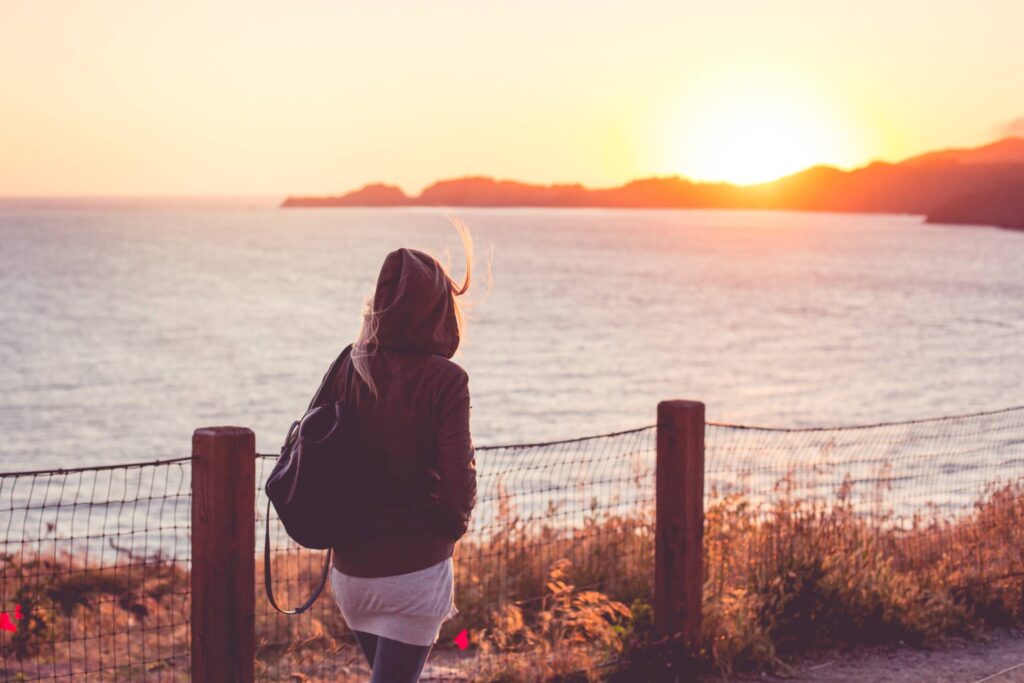 Young Girl on a Walk Near The Shore at Sunset Free Photo