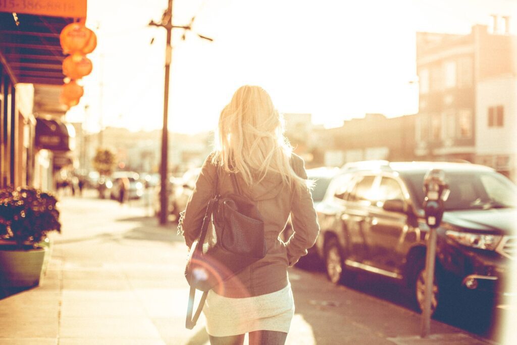 Young Girl Walking Down the Street Free Photo