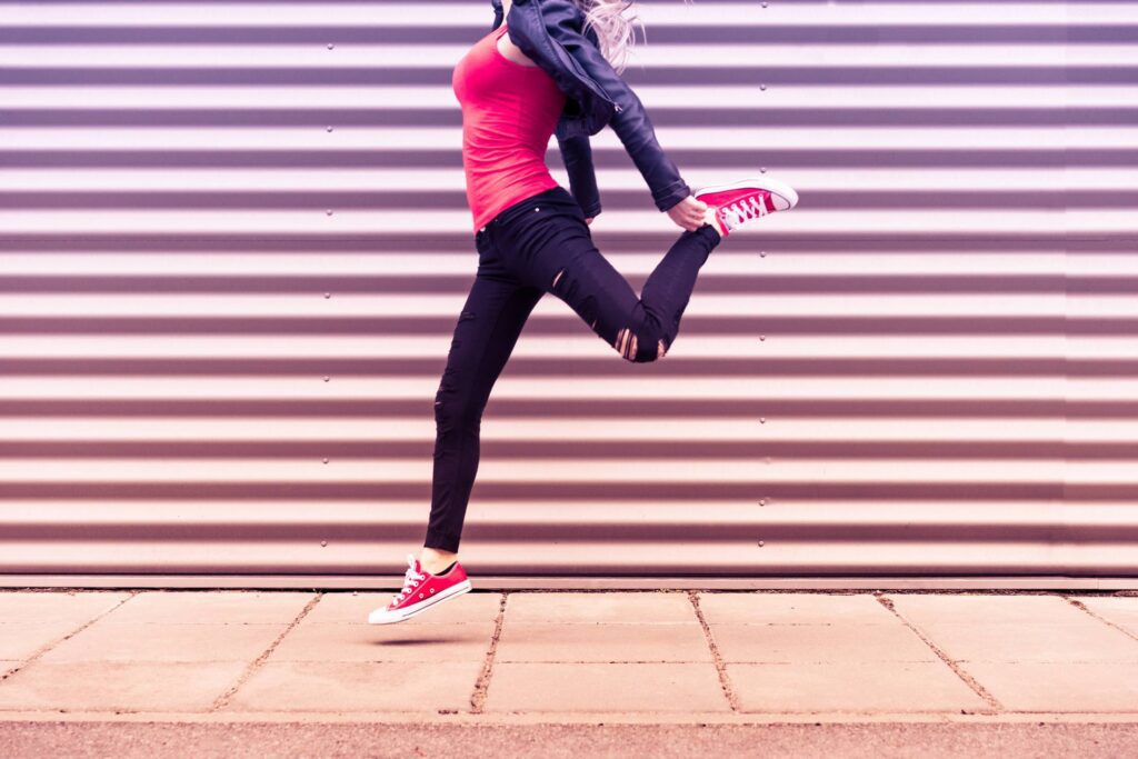 Young Happy Woman Jumping in Front of Metal Wall Free Photo