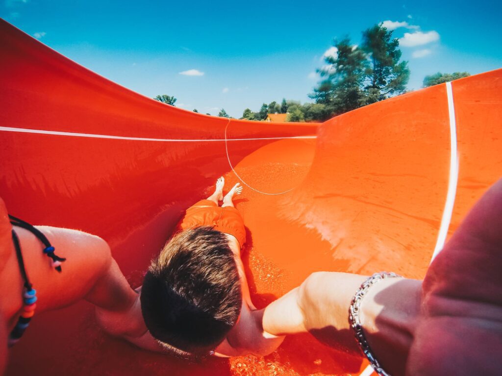 Young Man Enjoying Outdoor Water Slide Free Photo