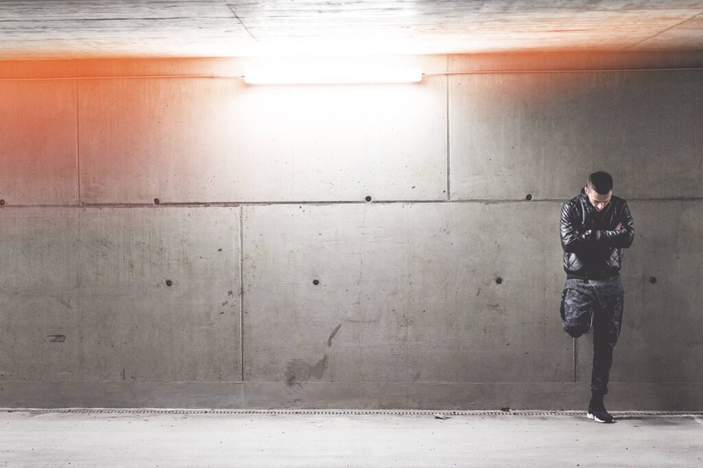 Young Man Standing In Front of Concrete Wall Free Photo