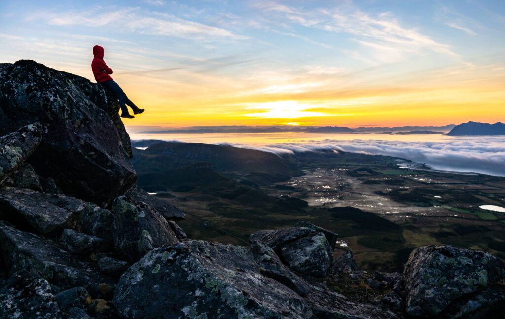 Young Man Watching the Sunrise From Top of the Mountain Free Photo