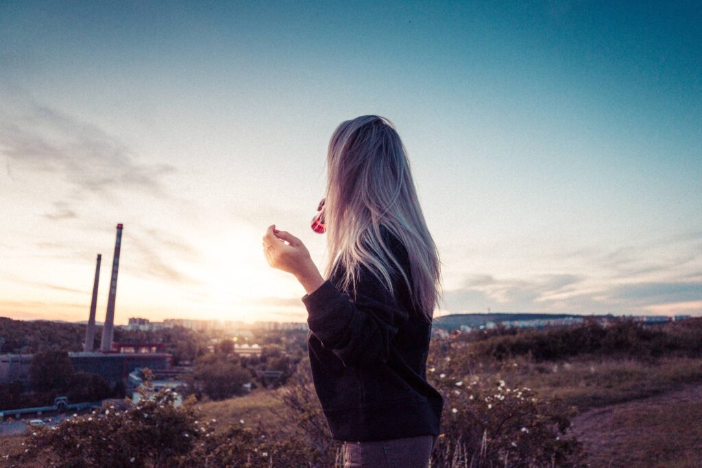 Young Millennial Girl Drinking Lemonade and Overlooking the City Free Photo