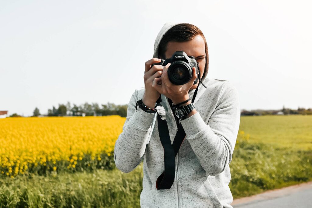 Young Photographer in Action Taking a Photo Free Photo