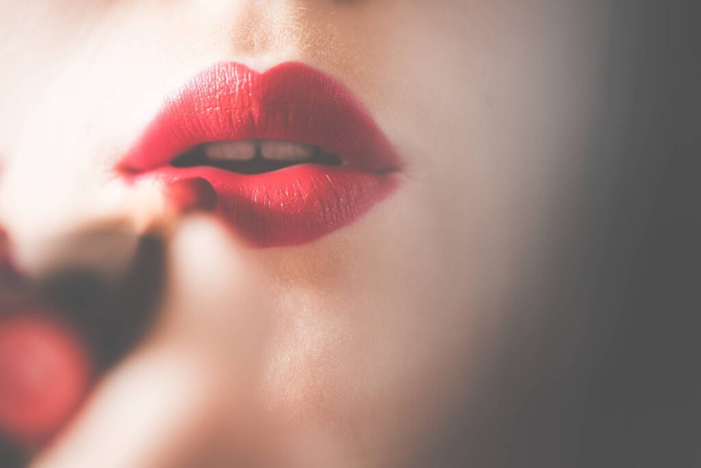 Young & Pretty Woman Applying Red Lipstick on Lips Free Photo