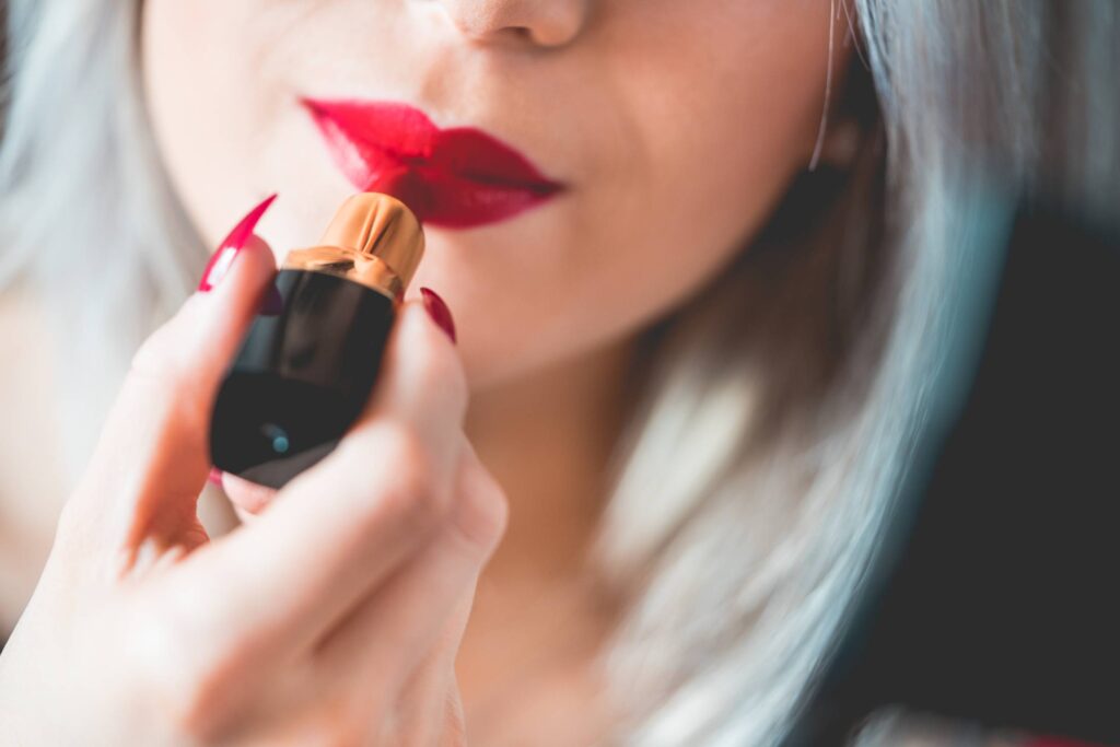 Young & Smiling Woman Applying Red Lipstick Free Photo