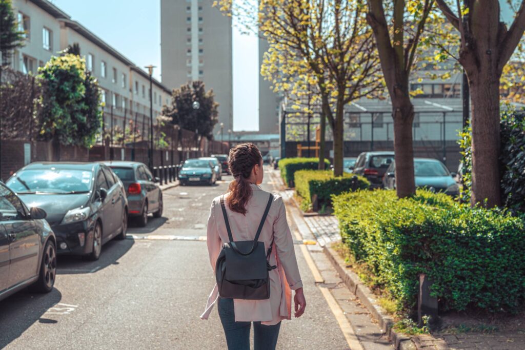 Young Solo Traveler Woman Walks Down a Street Free Photo