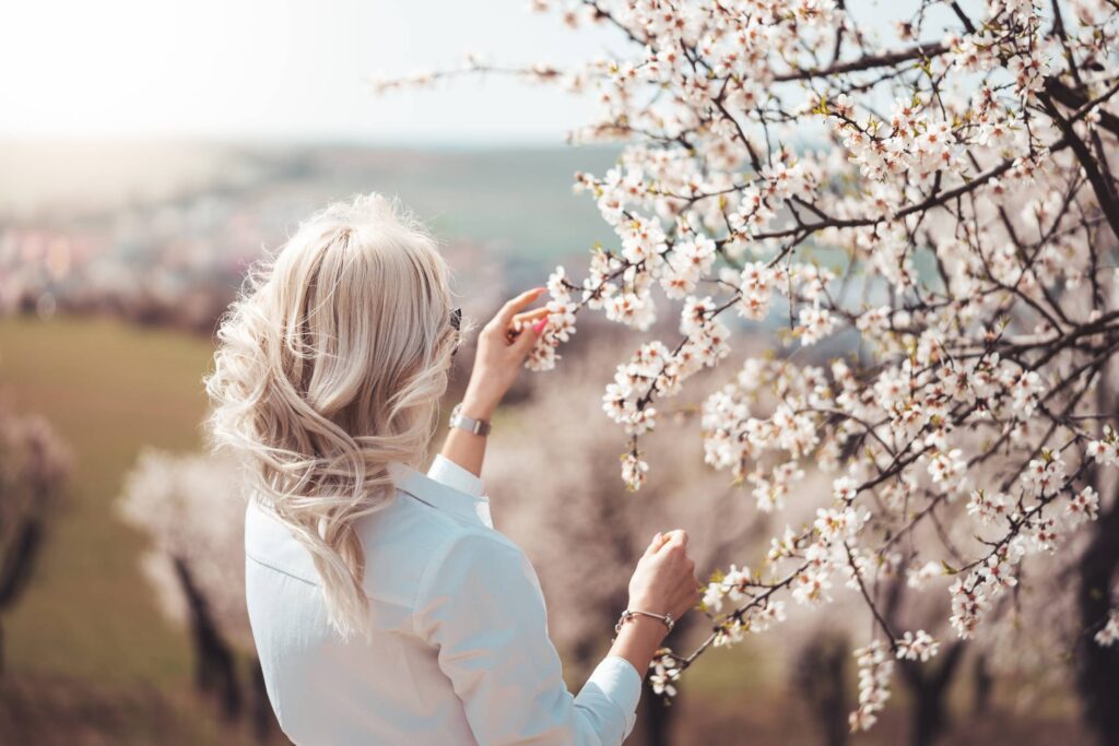 Young Woman Admiring Beauty of an Almond Tree Free Photo