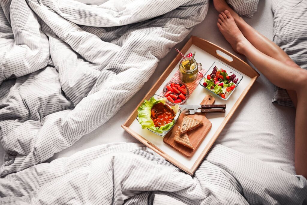 Young Woman Enjoying Morning Breakfast in Bed Free Photo