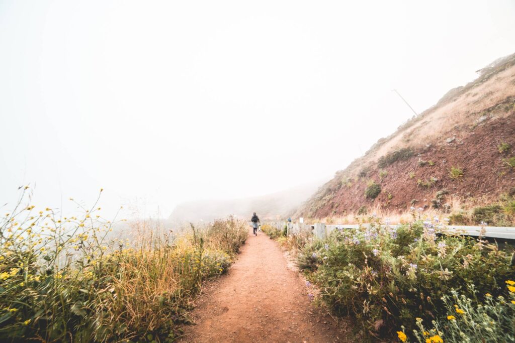 Young Woman Hiking the Mountain Trail in Foggy Weather Free Photo