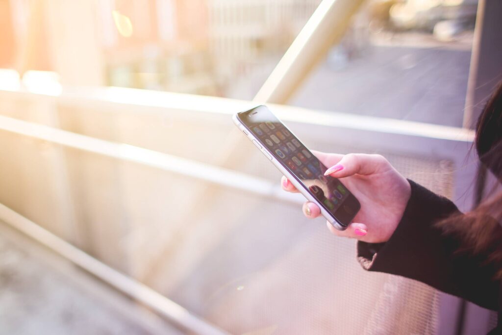 Young Woman Holding iPhone in Her Right Hand Free Photo