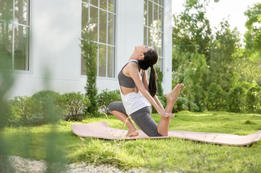 Young woman in sportswear doing meditation practice and yoga outdoor, healthy lifestyle, Mental health concept. Stock Free