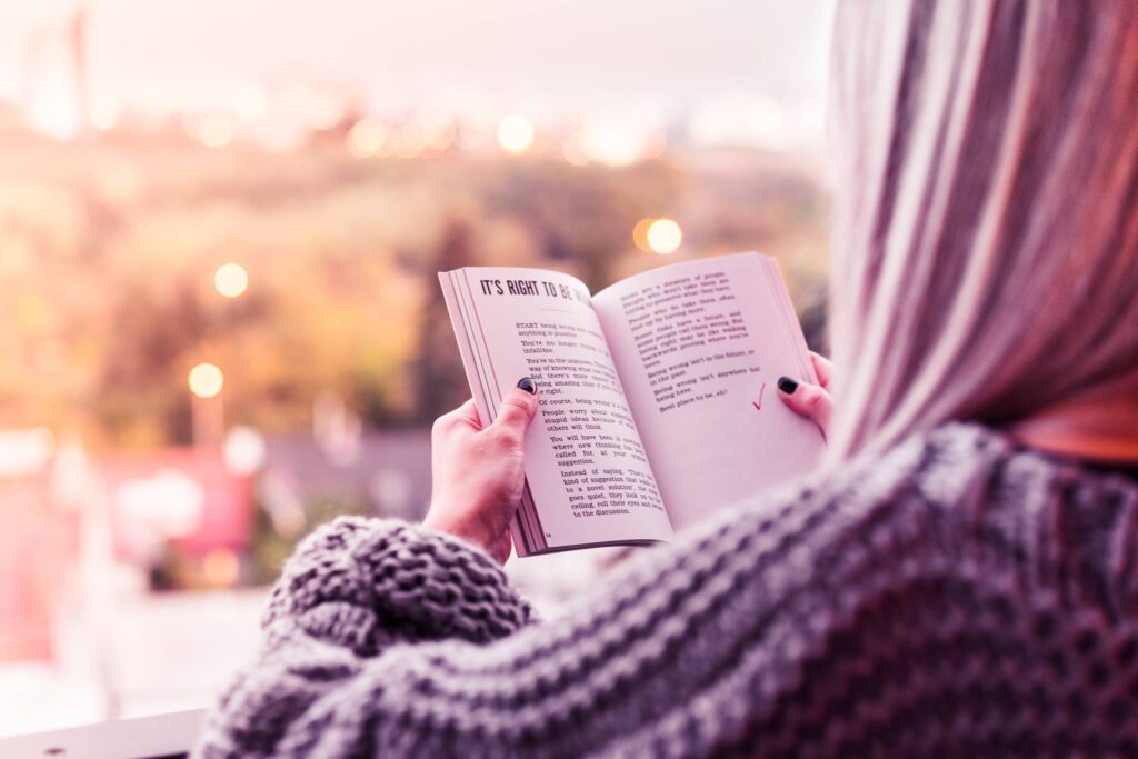 Young Woman Reading a Book on Terrace Free Photo