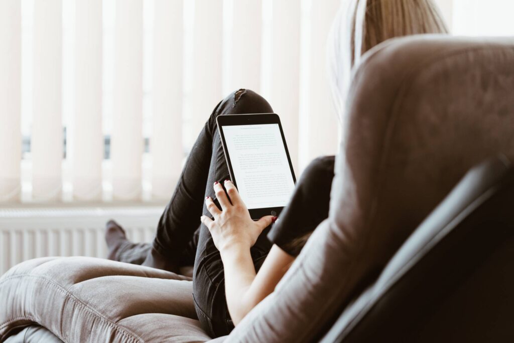 Young Woman Reading eBooks on Her iPad Tablet Free Photo