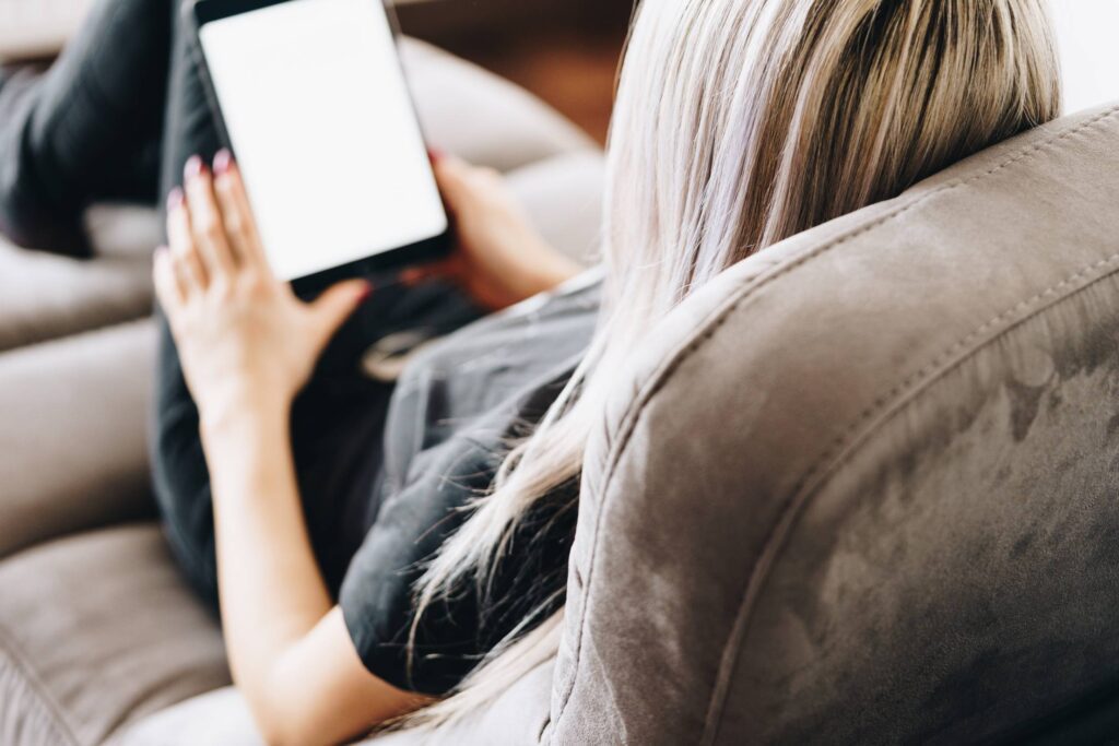 Young Woman Reading eBooks on Her Pocket Reader Free Photo