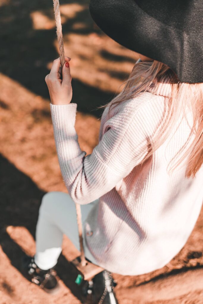 Young Woman Sitting on a Swing in The Park Free Photo