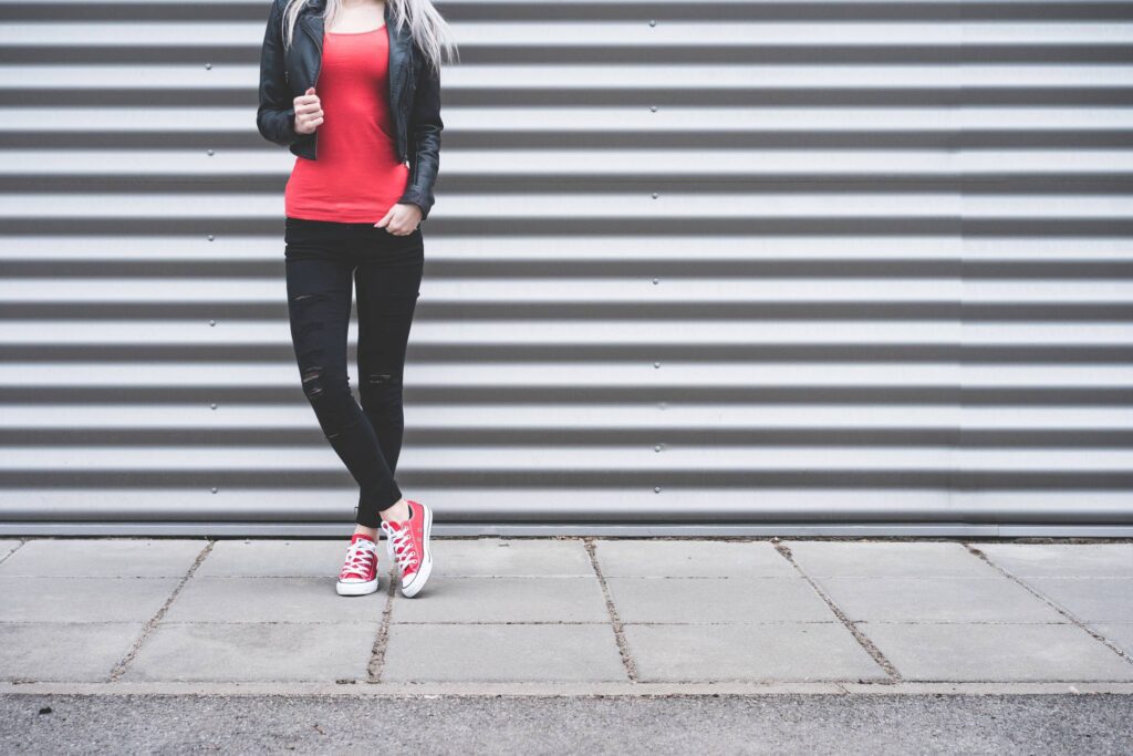 Young Woman Standing in Front of Metallic Wall Free Photo