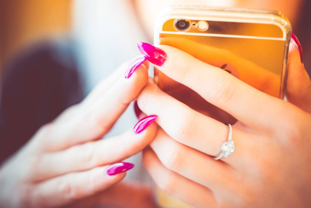 Young Woman Using Her Gold Smartphone Free Photo