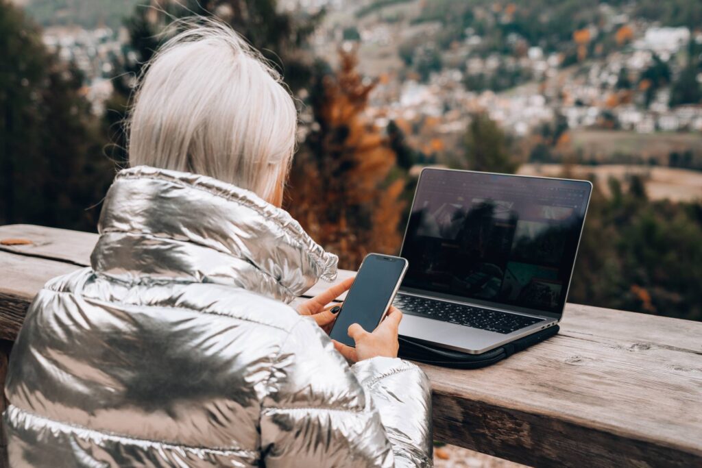 Young Woman Working Outdoors on a Laptop and a Mobile Free Photo