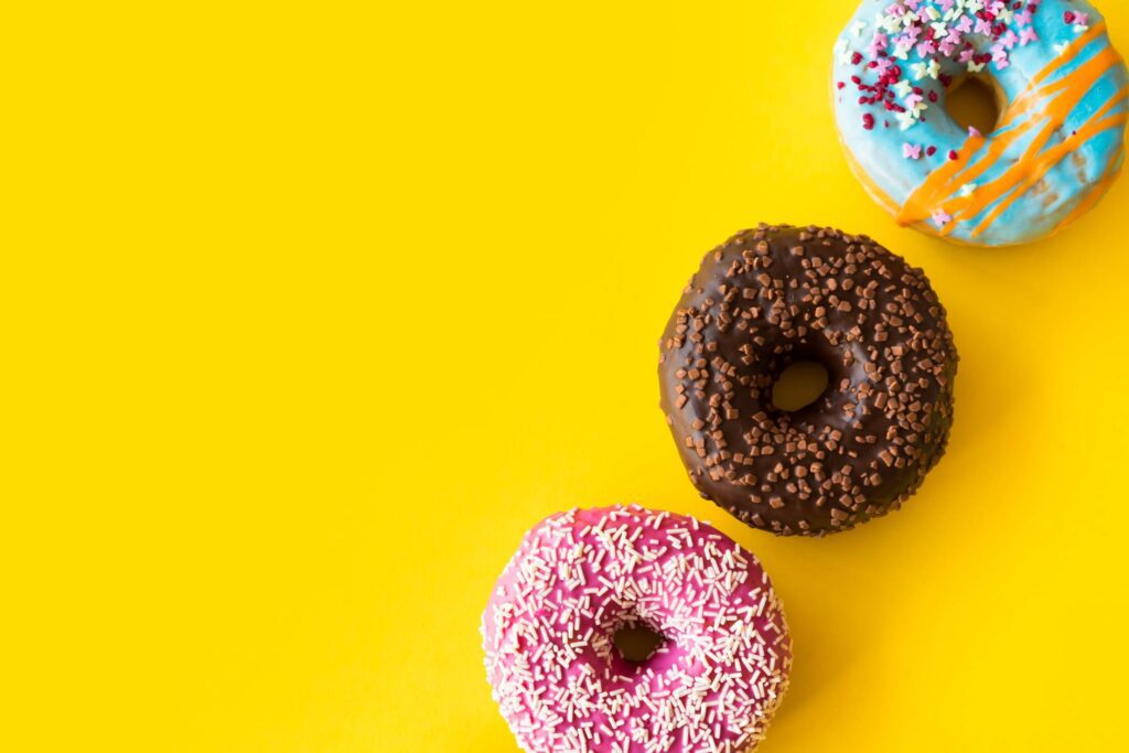 Yummy Donuts on Yellow Background Free Photo