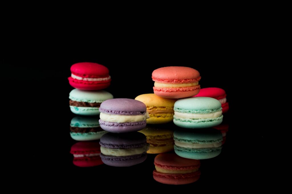 Yummy Macarons on Black Glossy Background Isolated Free Photo