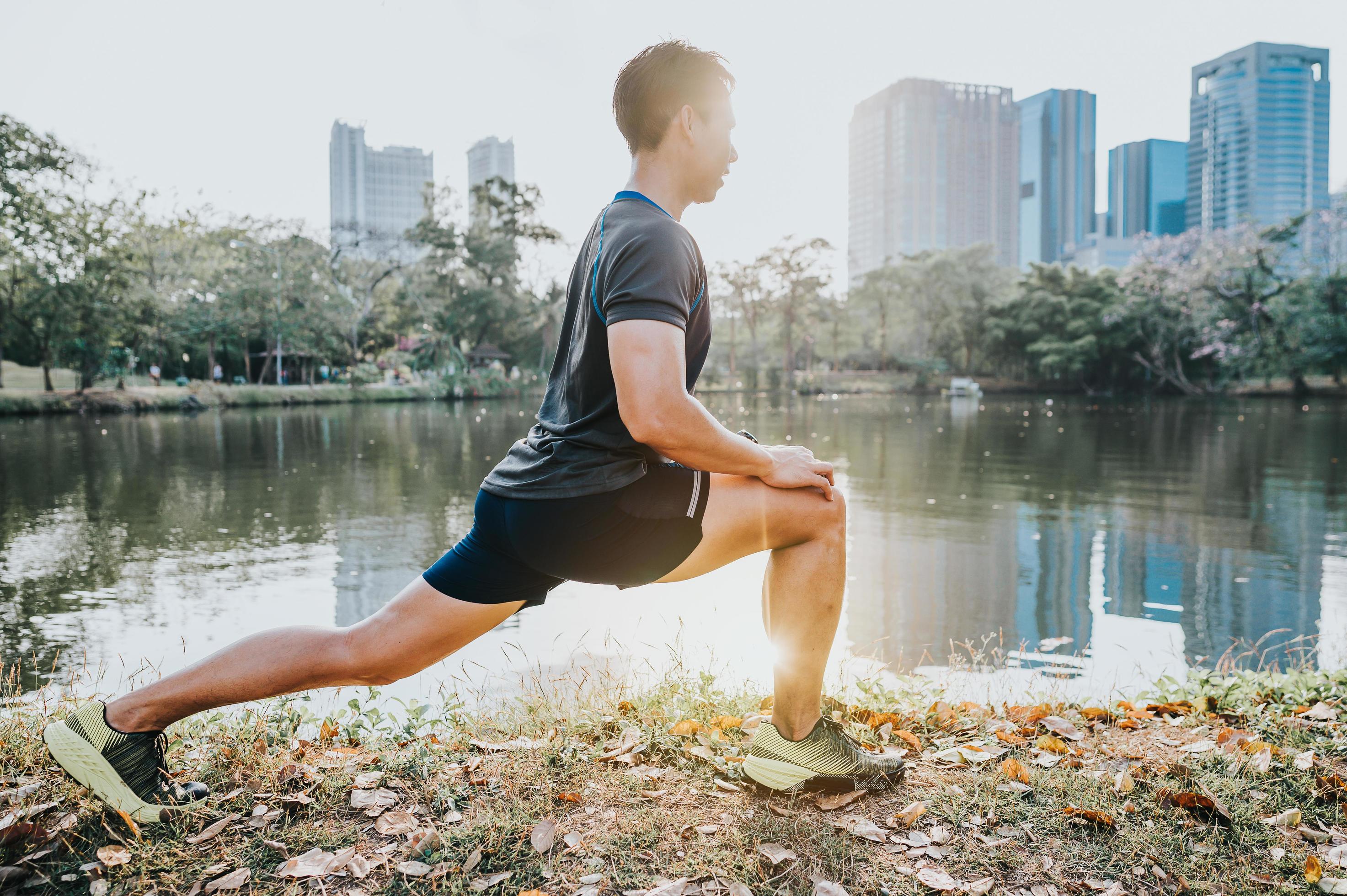 Runner doing stretching exercise Stock Free