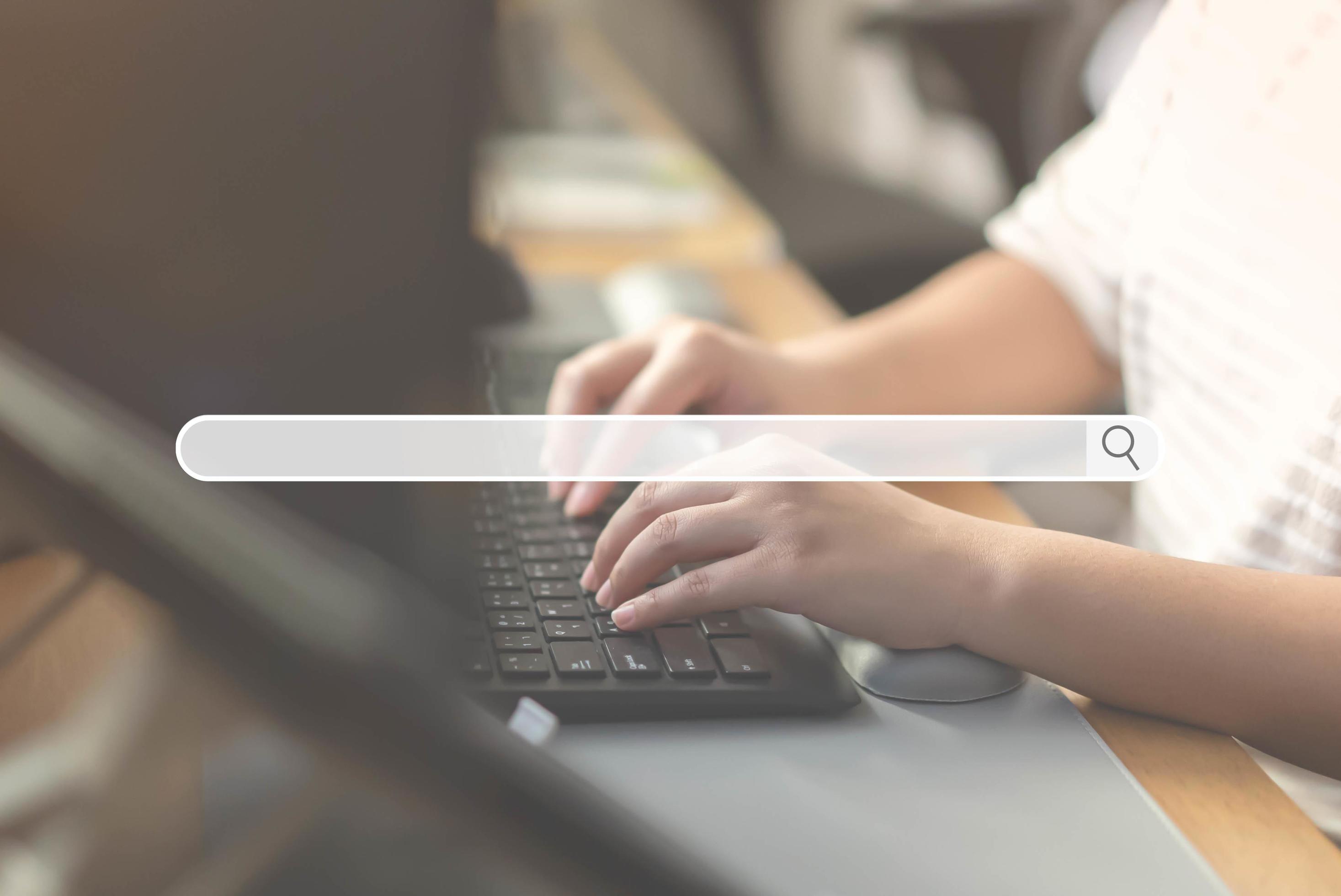 Close up of human hand typing on computer keyboard as background of search engine browser Stock Free