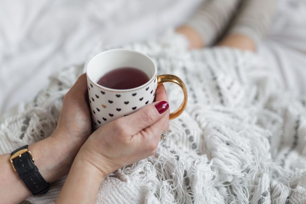 Soft photo of woman on the bed with the book and cup of coffee in hands Stock Free