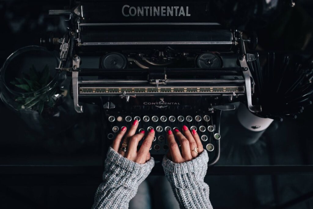 Woman typing on an old typewriter Stock Free