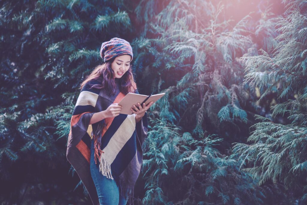 Young woman relax in the holiday. Travel nature and write a note Happy to see the beauty of the pine leaf. Nature Study. Stock Free