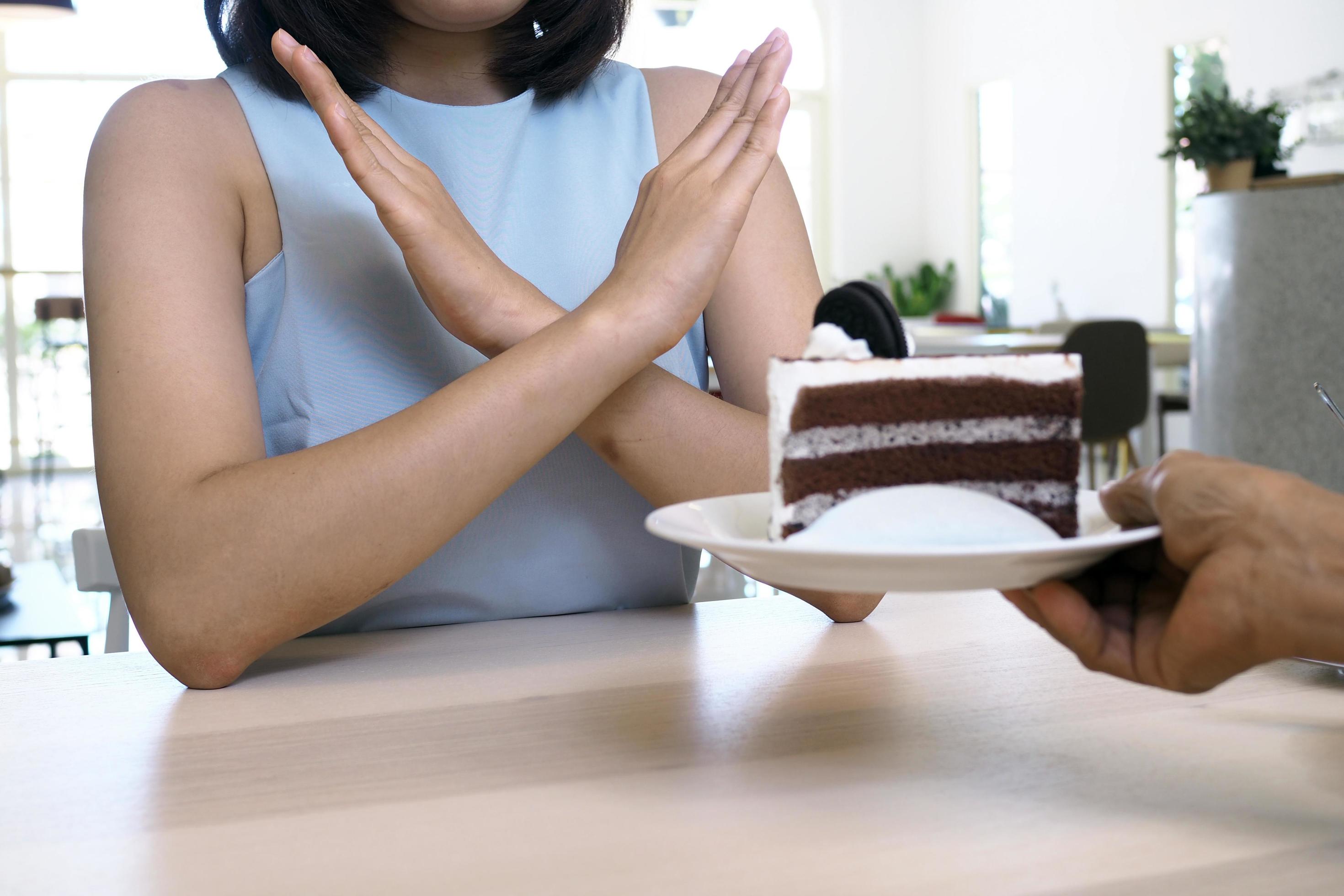 One of the health-care girls used a hand to push a plate of chocolate cake. Refuse to eat foods that contain Trans Fat. Stock Free