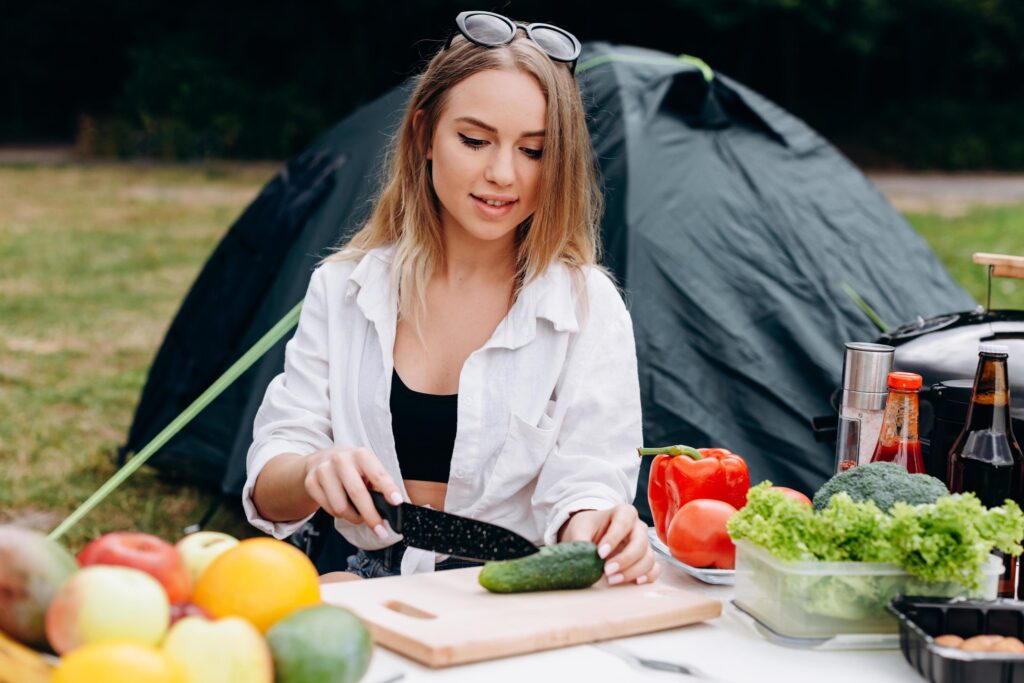 Woman preparing food outdoor in the camping Stock Free