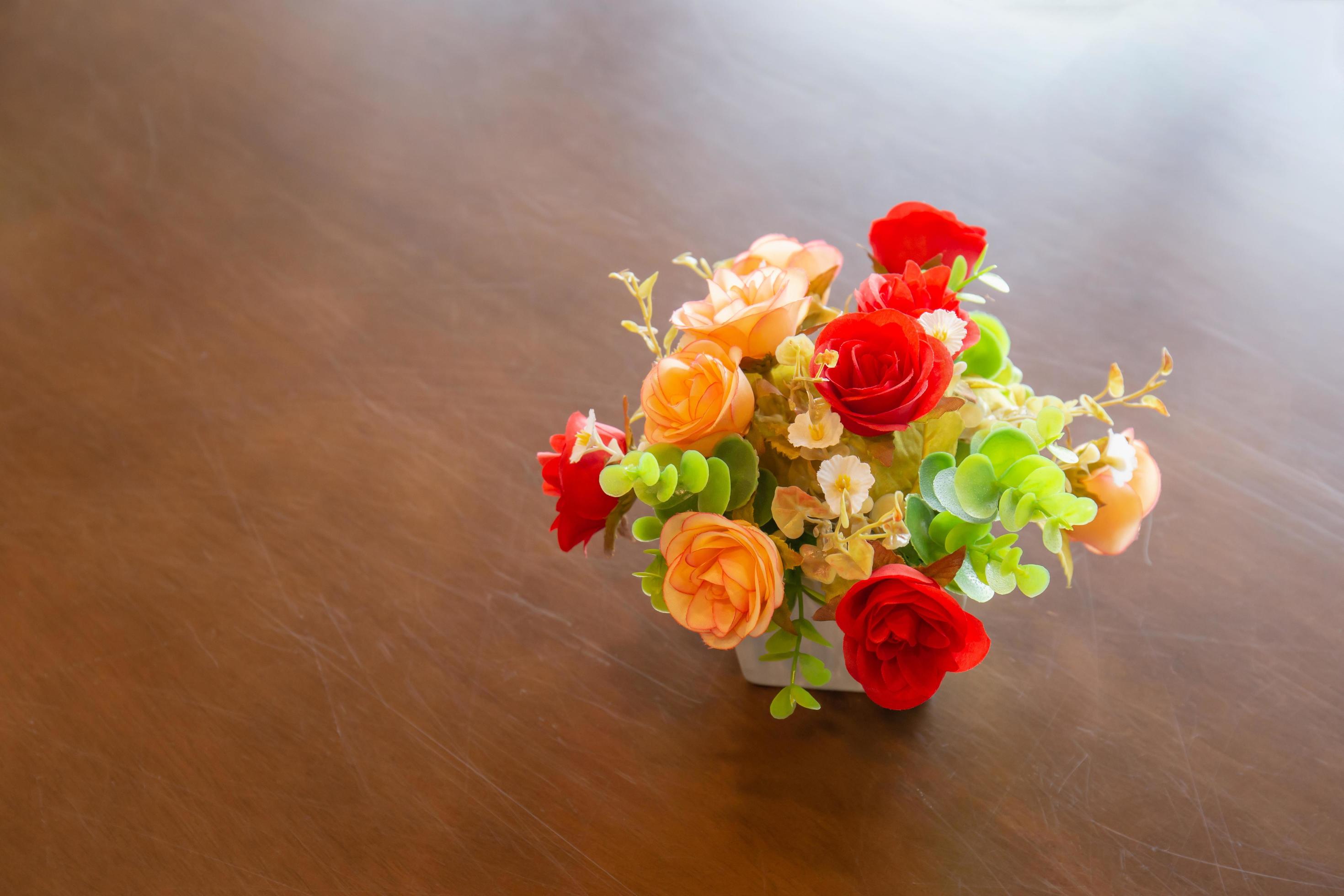 Bouquet of beautiful flowers in a modern vase on wooden table for home decoration Stock Free